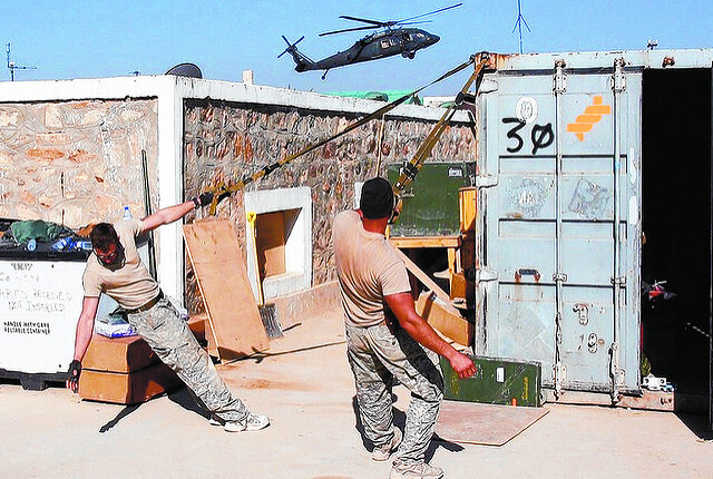 Suspension trainer anchored outdoors with a soldier training in the open air