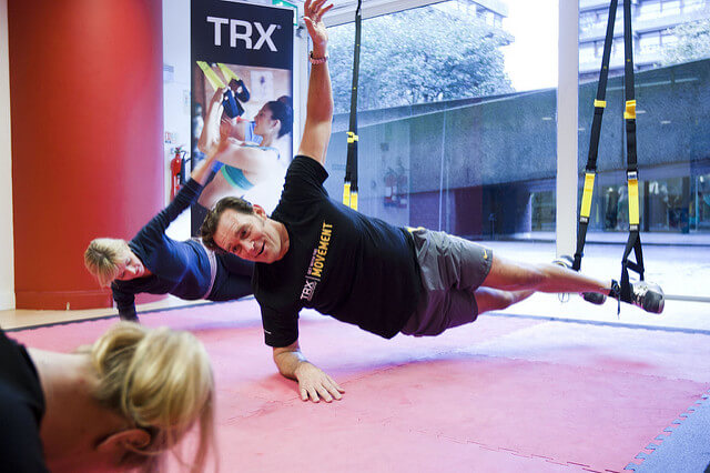Athlete performing a suspended row with both handles gripped at chest height